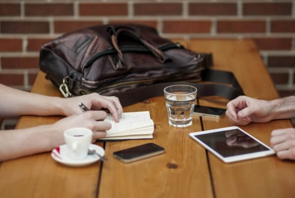 friends-sitting-in-cafe-writing-in-notebook-with-digital-tablet-and-coffee-cup_1