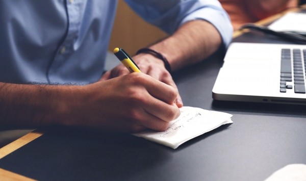 man-writing-in-notebook