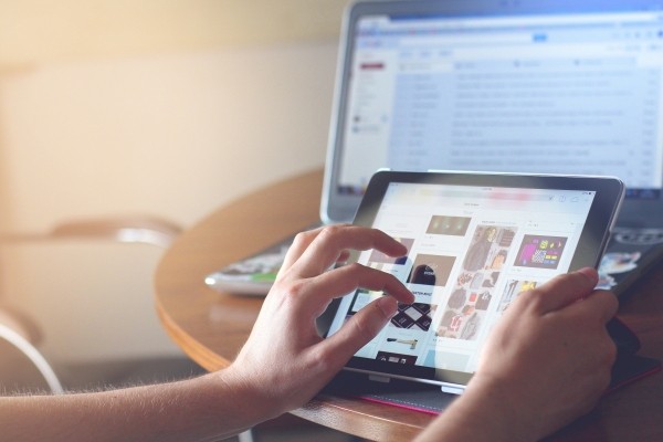 woman-using-digital-tablet-with-laptop-in-background